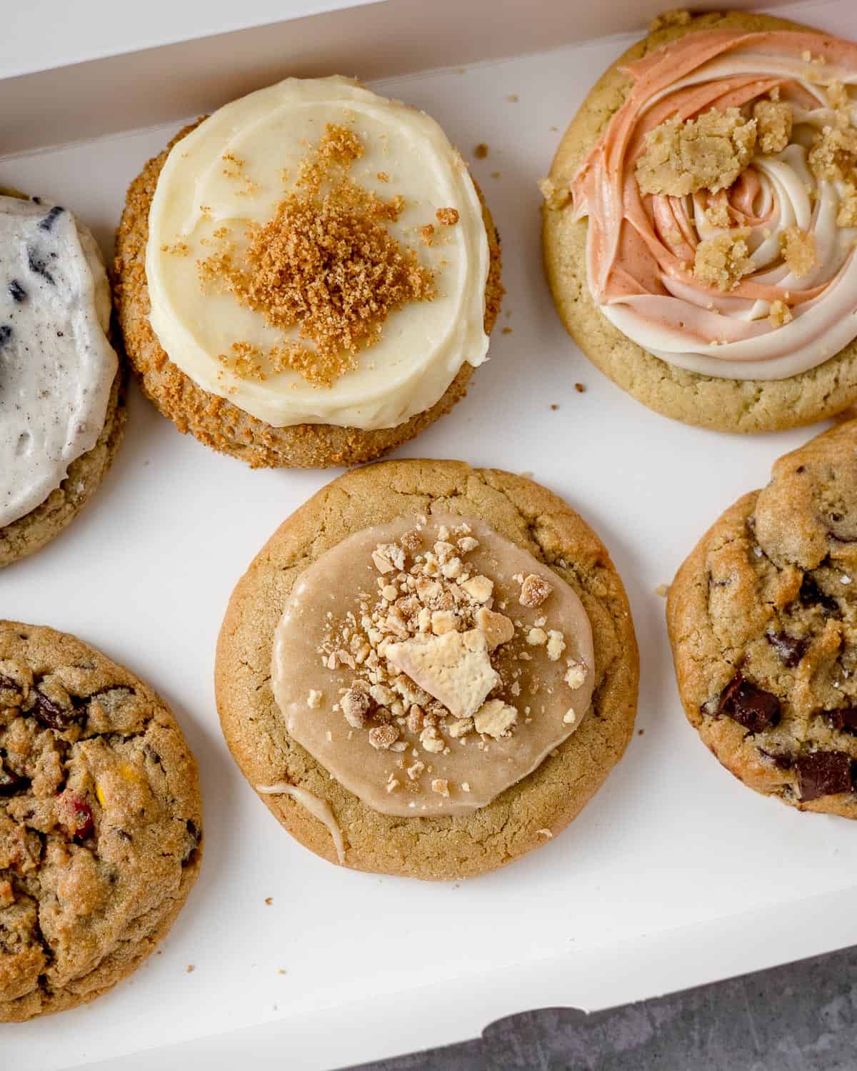 A six-pack of Crumbl Cookies packed in a box.