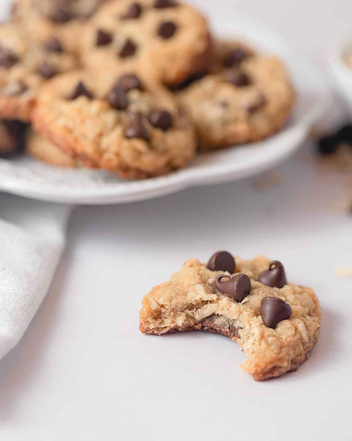 A chocolate chip cookie with a bite removed.