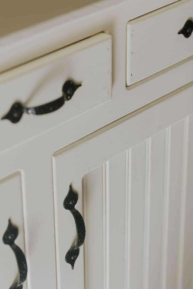 A bead board cupboard door on a white painted hutch.