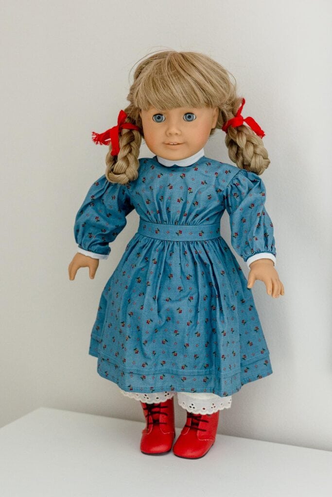 Pleasant Company Kirsten doll in blue floral "meet" dress with white trim.