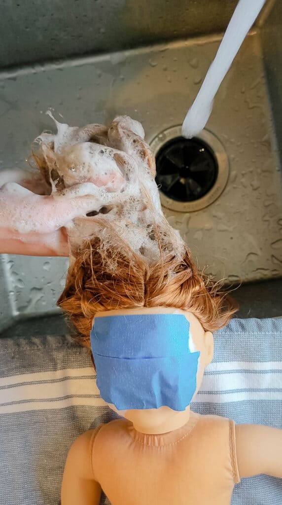 Scrubbing a used thrift store doll with gentle dish soap.